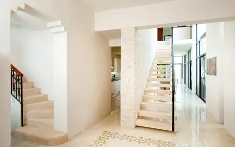 Pasillos con encanto, con escaleras de diseño moderno y clásico, y un suelo de baldosas con motivos dorados.