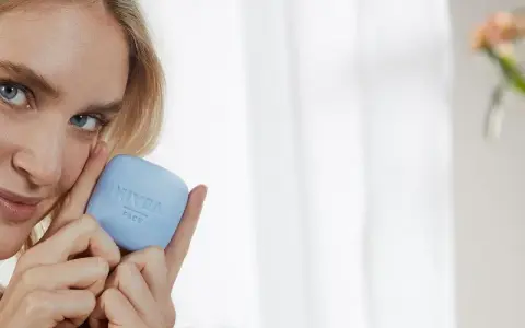 Une femme blonde tient un pain de savon bleu Nivea Face. Elle sourit, sa peau semble douce. Ce savon a un pH neutre, combien est-il doux pour votre visage ?