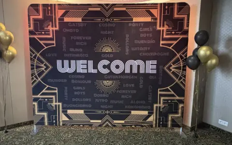 Tło w stylu lat 20. z napisem "WELCOME" i złotymi balonami.