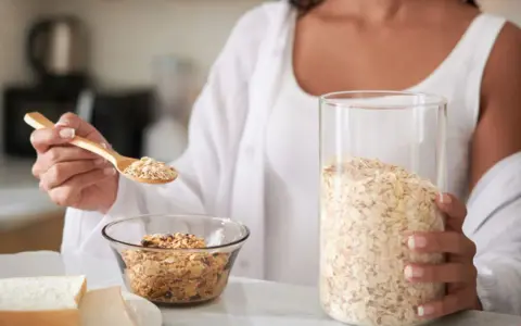 Mujer preparando un desayuno saludable. La avena es antiinflamatoria y perfecta para empezar el día con energía.