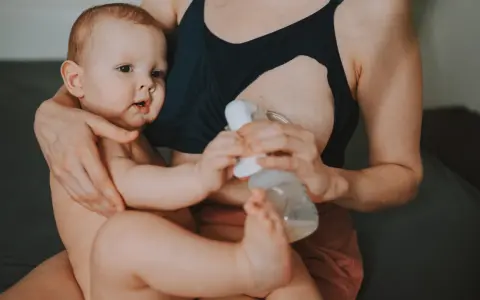 Mama karmi piersią i odciąga pokarm, pokazując, jak karmienie piersią a praca mogą iść w parze.