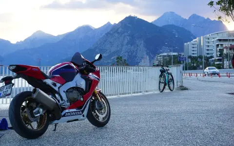 Sportowy motocykl Honda i dwa rowery na tle gór. Wyobraź sobie podróż po **tajlandii północnej** na tym sprzęcie.