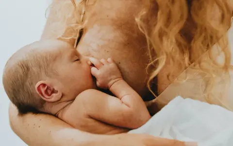 Ein Baby wird gestillt. Manchmal, wenn es schreit, fühlt sich die Mutter überfordert, aber hier ist es friedlich.