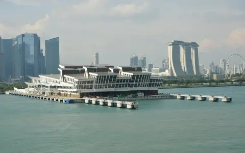 Moderno terminal crociere galleggiante nel **singapore porto**, con grattacieli iconici sullo sfondo.