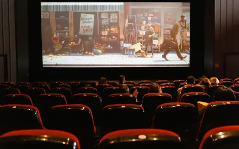 Una sala de cine con público observando una película animada. Esto es que es el cine: una experiencia compartida de historias en pantalla grande.