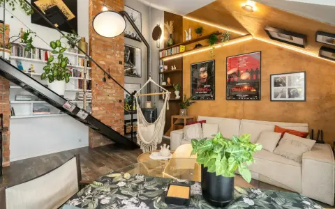 Przytulny mały pokój w stylu loft z ceglaną ścianą, metalowymi schodami, wiszącym fotelem i wygodną kanapą.