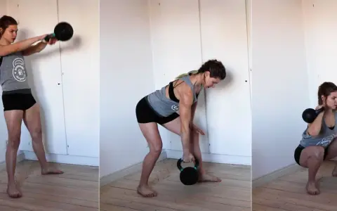 Kvinnan utför marklyft med kettlebell, en dynamisk övning som involverar svingar och knäböj för att bygga styrka.