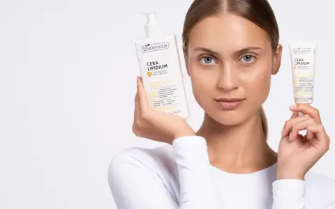 Kobieta prezentuje emulsję i krem Bielenda Cera Lipidum. Produkty z linii linoderm odbudowują barierę lipidową skóry.