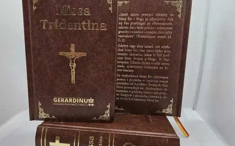 Brązowe księgi z napisem "Missa Tridentina" i złotym krzyżem. Jedna otwarta, z tekstem o Mszy Świętej.