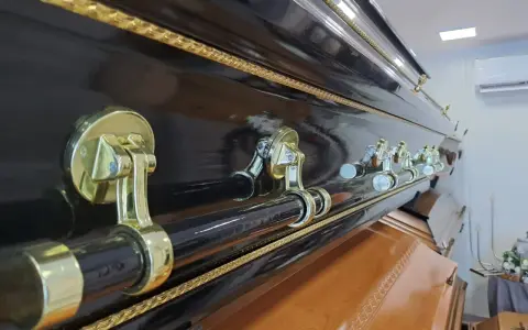 Elegancka, czarna trumna z ozdobnymi uchwytami. Warto pomyśleć, jak napisać ostatnie pożegnanie, gdy przyjdzie taki moment.