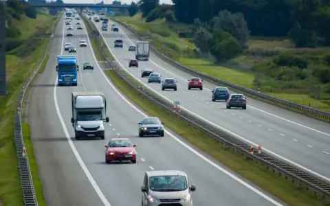 Ruch na autostradzie, gdzie samochody jadą różnymi pasami. Pytanie, czy na autostradzie można wyprzedzać z prawej strony, jest kluczowe dla bezpieczeństwa.