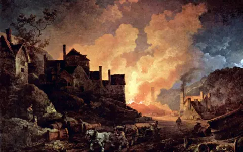 Un paisaje industrial con humo y fuego, que evoca **qué es la revolución industrial**. Casas y carretas con caballos completan la escena.