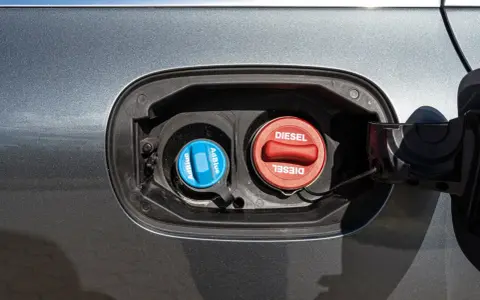 Dwa korki wlewu paliwa: czerwony z napisem DIESEL i niebieski z napisem AdBlue. AdBlue to płyn stosowany w nowoczesnych dieslach.