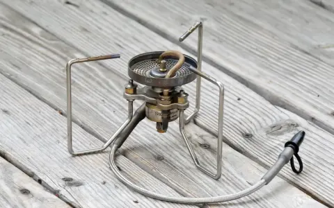 Soto Stormbreaker Campingkocher auf Holzoberfläche. Kompakt und robust für Outdoor-Abenteuer.