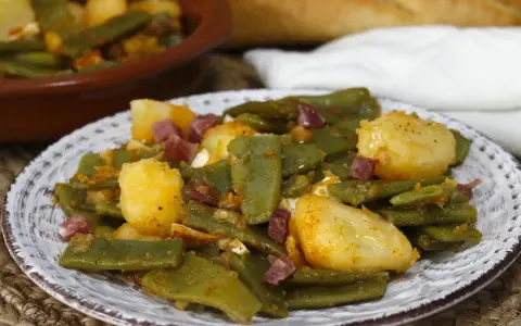 Plato de judías verdes con jamón y patatas, un clásico casero.