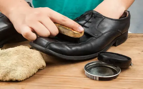 Czyszczenie czarnych skórzanych butów. Użyj szczotki i pasty, by nadać im blask.