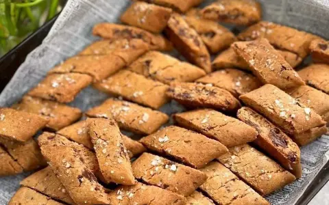 En hög med gyllene kolakakor med chokladbitar och flingsalt. Perfekt för ett enkelt kolakakor recept.