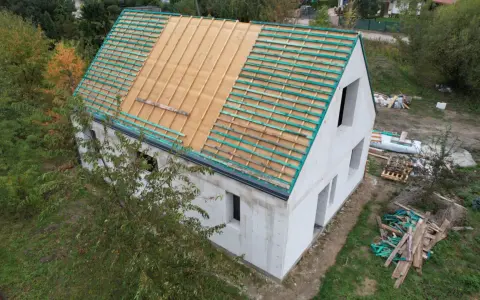 Budowa projektu domu 30m2 w trakcie. Widoczna konstrukcja dachu z łatami.