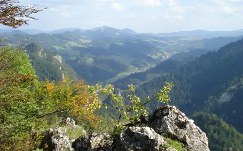 Widok z bacówki Trzy Korony na malowniczą dolinę Pienin. W oddali widać góry i lasy.