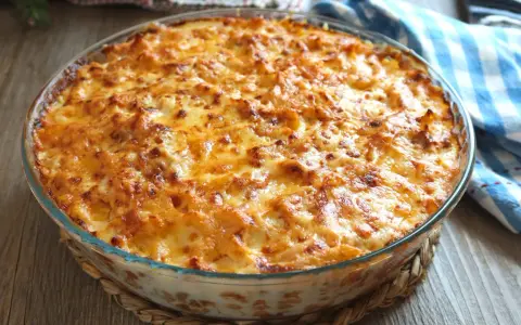 Macarrones al horno dorados y burbujeantes en una fuente de cristal, listos para servir.