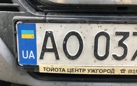 Ukraińskie tablice rejestracyjne z flagą i literami "UA" na białym tle. Widoczne cyfry "AO 037".