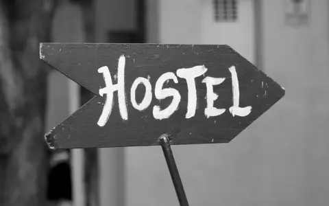 Piltavla med texten "Hostel" i vit färg, pekar åt höger. Enkel skylt som leder dig till ditt vandrarhem i Dalsland.