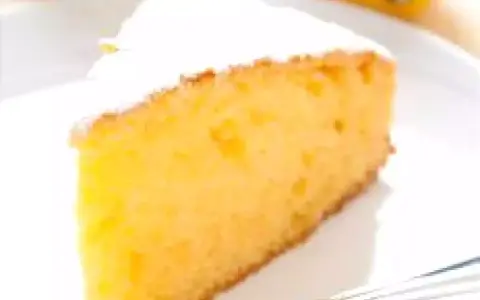 Una fetta di torta soffice e dorata, spolverata di zucchero a velo. Perfetta per una torta facile e veloce da preparare.
