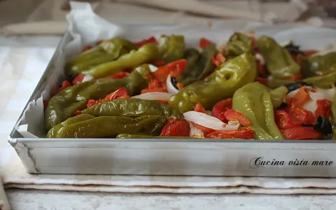 Friggitelli al forno con pomodoro e cipolla, un contorno saporito e colorato, pronto per essere gustato.