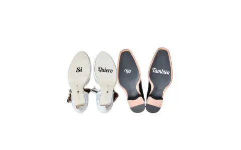 Pegatinas en zapatos de boda: "Sí, quiero" en tacones y "Yo también" en zapatos de hombre.