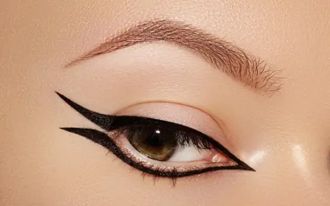 Occhio con un audace **reverse eyeliner** nero, che incornicia la palpebra inferiore e si estende verso l'alto, creando un look grafico e sofisticato.