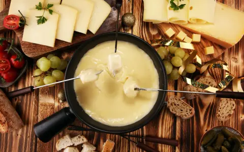 Fondue au fromage, une spécialité Rhône Alpes, avec pain, raisins et tomates cerises.