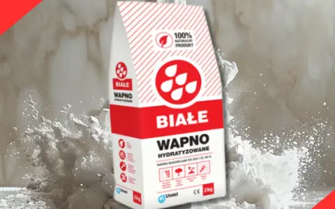 Białe wapno budowlane w worku, otoczone chmurą białego pyłu. Idealne do prac remontowych.