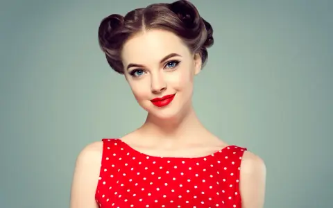 Eleganckie fryzury retro na wesele, z kręconymi kokami i czerwoną sukienką w grochy.