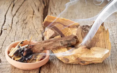 Fragmentos de palo santo humeante sobre madera rústica. Quemar palo santo es malo para el medio ambiente y la salud.