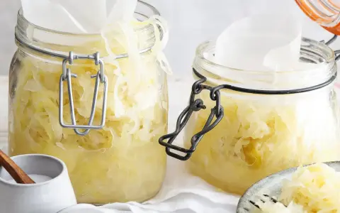 Zwei Gläser mit hausgemachtem Sauerkraut, bereit für die Fermentation. Ein einfaches Sauerkraut Rezept für gesunde Beilagen.