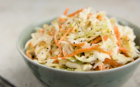 Krämig coleslaw med strimlad vitkål och morot, perfekt till grillat. Ett enkelt coleslaw recept för alla tillfällen.