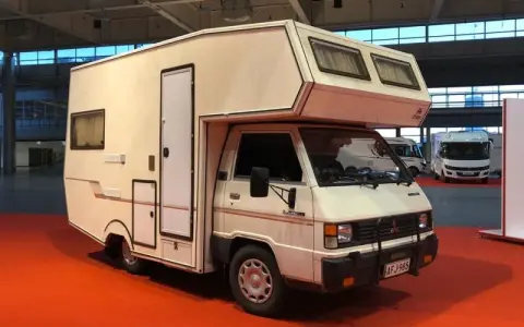Biały kamper Mitsubishi L300 z zabudową mieszkalną, gotowy na przygody.