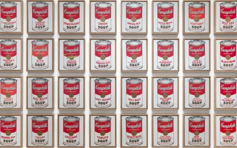 Andy Warhol's repetition art showcases a grid of Campbell's soup cans, each a unique flavor, creating a vibrant pop art statement.