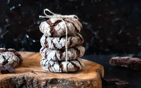 Pile de craquelins au chocolat, parfaits pour une recette facile. Ils sont liés par une ficelle et posés sur une planche en bois.