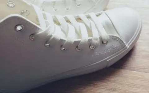 Primer plano de unas zapatillas blancas de tela, listas para limpiar y lucir impecables.
