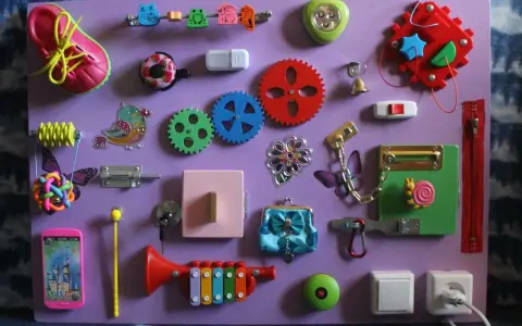 Lavagna sensoriale fai da te con scarpa, ingranaggi, campanello, lucchetto e altri elementi per stimolare i bambini. Perfetta per giochi montessori 2 anni fai da te.