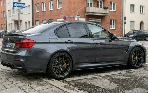 Grauer BMW M3 parkt auf Kopfsteinpflaster. Die Werkstatt bekommt das Ersatzteil nicht, der Wagen wartet.