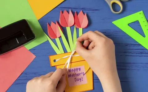 Dziecko tworzy kartkę z tulipanami i napisem "Happy Mother's Day!". To piękne prezenty robione przez dzieci.
