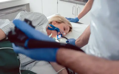 Pacjentka poddana endoskopii w celu diagnozy eozynofilowego zapalenia przełyku. Lekarz wprowadza endoskop.