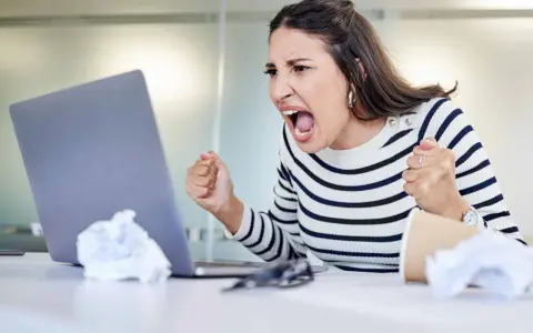 Wütende Frau schreit vor Laptop, frustriert über Probleme im **bad neighbourhood**.