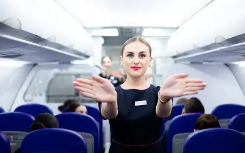 Uśmiechnięta stewardessa Wizzair wita pasażerów. Czy trzeba drukować kartę pokładową Wizzair? Sprawdź przed podróżą!