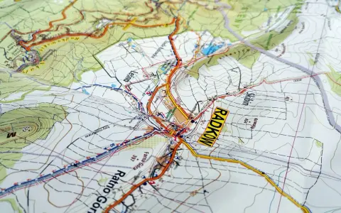 Mapa turystyczna z zaznaczonymi szlakami i miejscowościami, w tym Radkowem. Widoczne są **góry stołowe** i ukształtowanie terenu.