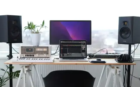 Studio z monitorami Adam Audio T7V, laptopem, klawiaturą i mikserem. Idealne miejsce do tworzenia muzyki.