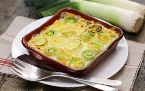Puerros al horno gratinados, tiernos y dorados, listos para disfrutar.