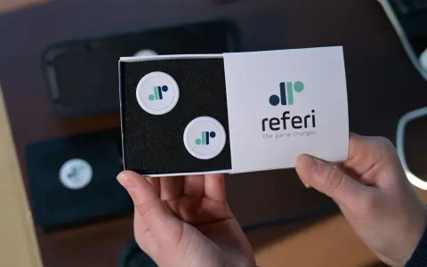 Scatola con due gettoni e logo "referi", un segnapunti online gratis per cambiare il gioco.